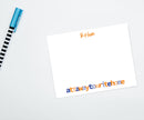 A personalized notecard with 'Ethan' written at the top and the phrase 'Attawaytowritehome' printed at the bottom. The card is placed on a white surface with a blue and white striped pen to the side.