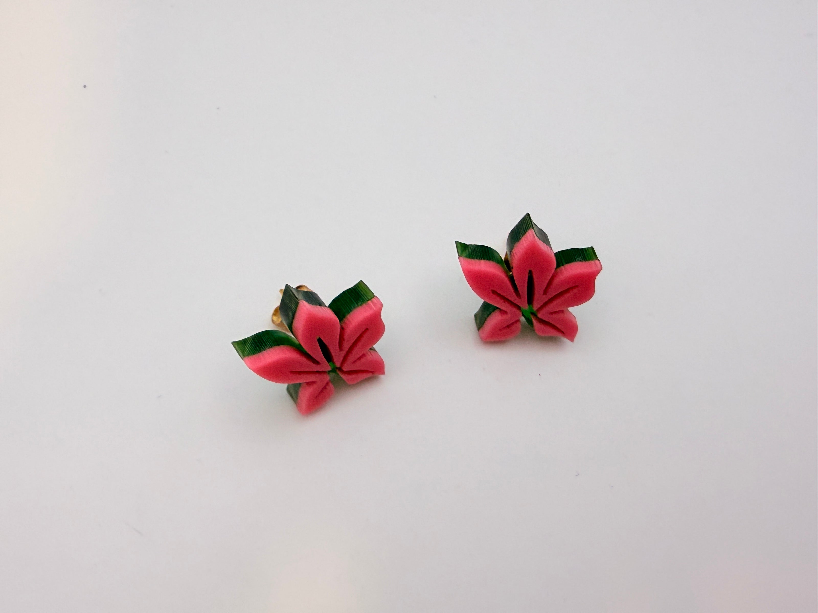 Pair of pink flower-shaped earrings on a white background
