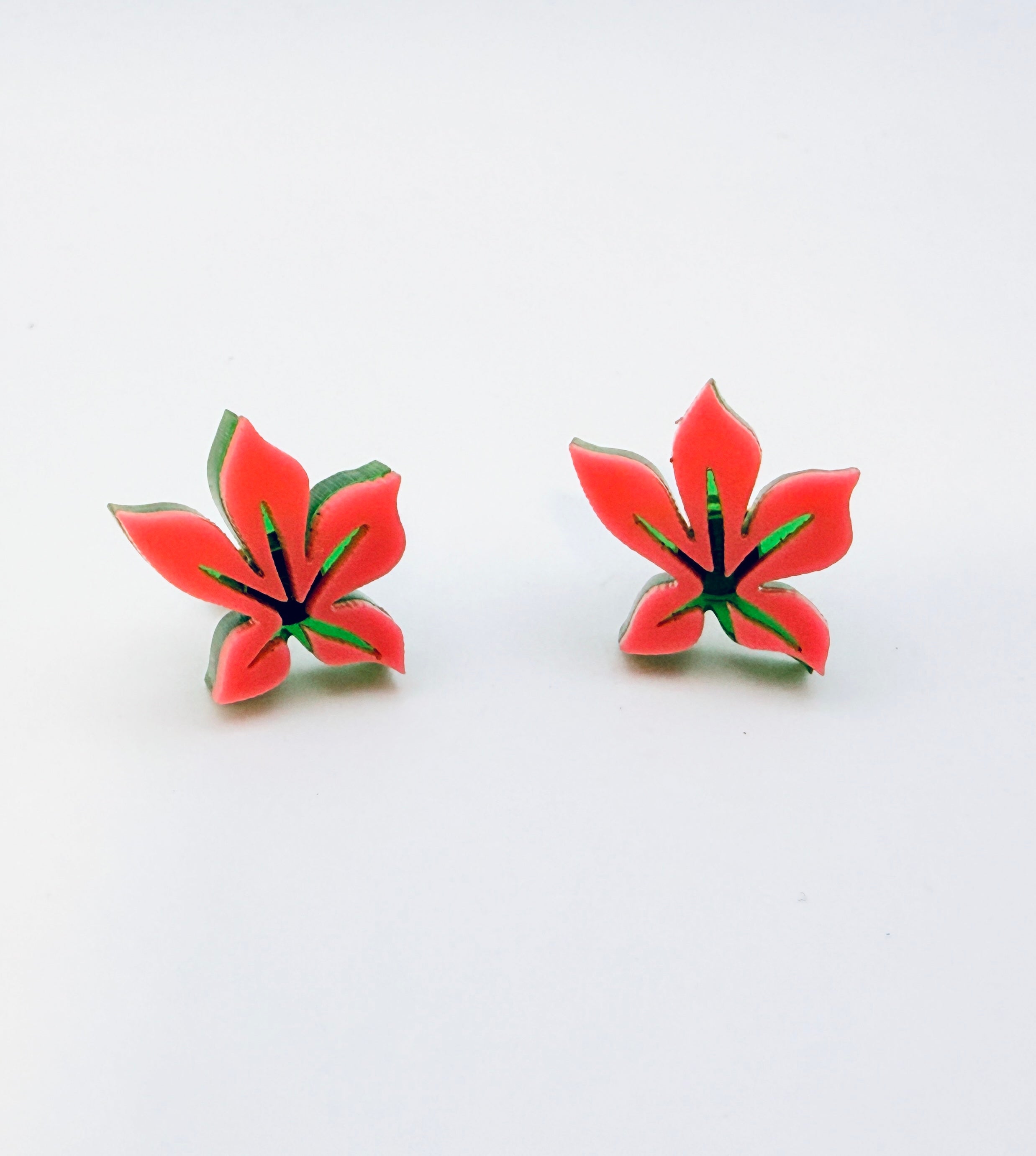 Pair of pink flower-shaped earrings on a white background