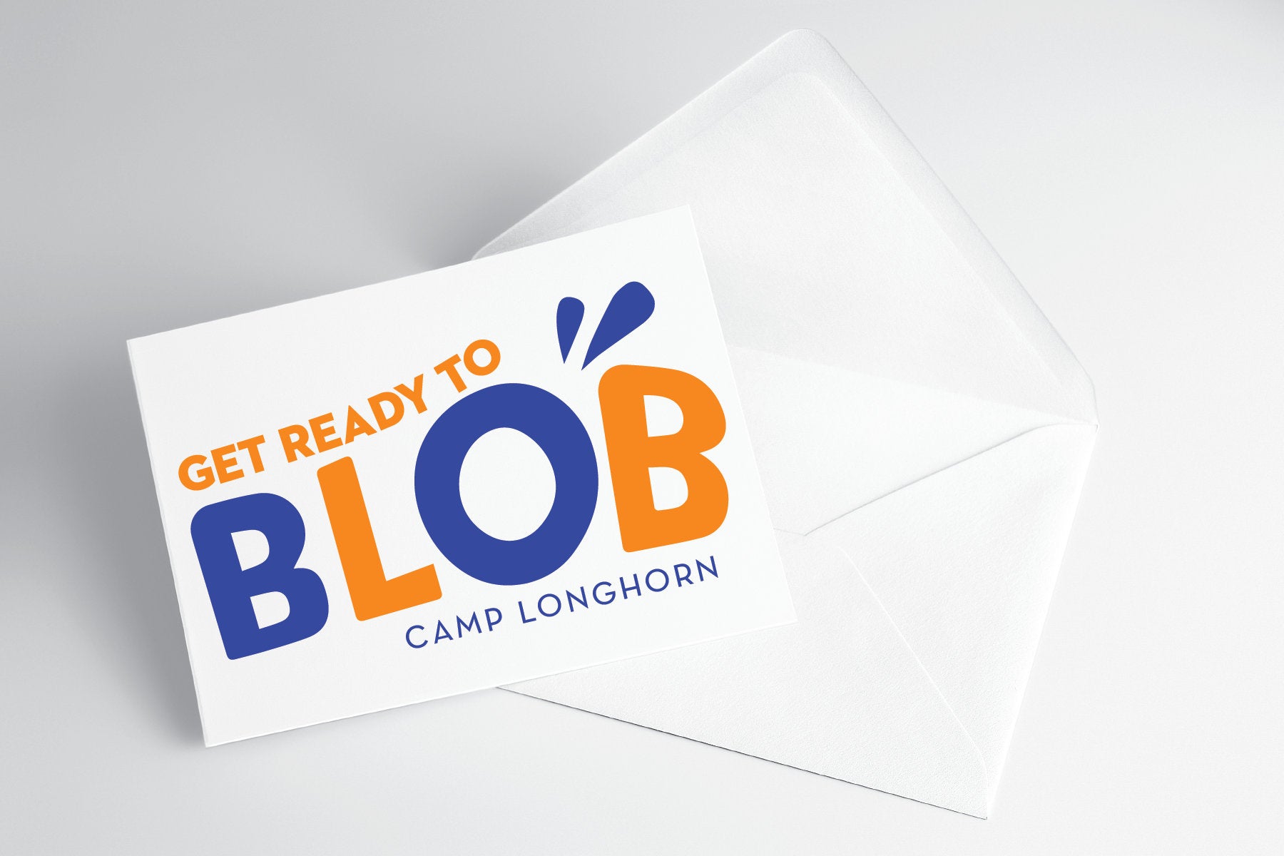 A folded note card with 'Get Ready to Blob - Camp Longhorn' text and a blue and orange design, placed on a white background.