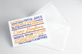 A folded note card with a 'Camp Longhorn' design, featuring text in blue and orange on a white background, placed on a clear background.