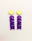 Pair of earrings with purple 'GEAUX' letters and gold heart tops on a white background