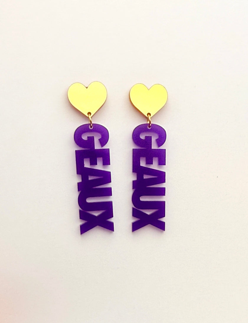 Pair of earrings with purple 'GEAUX' letters and gold heart tops on a white background