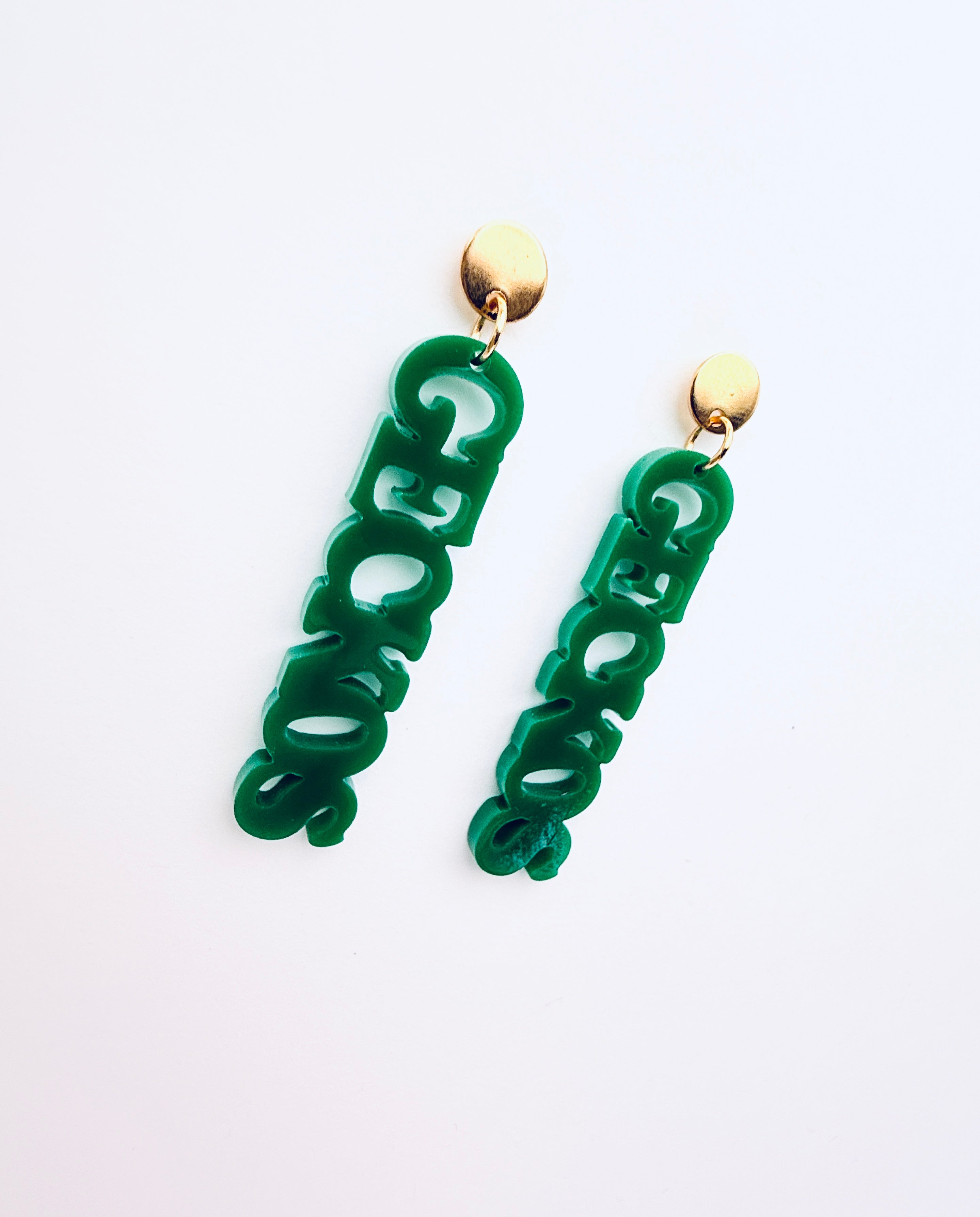 Green earrings with gold hooks on a white background