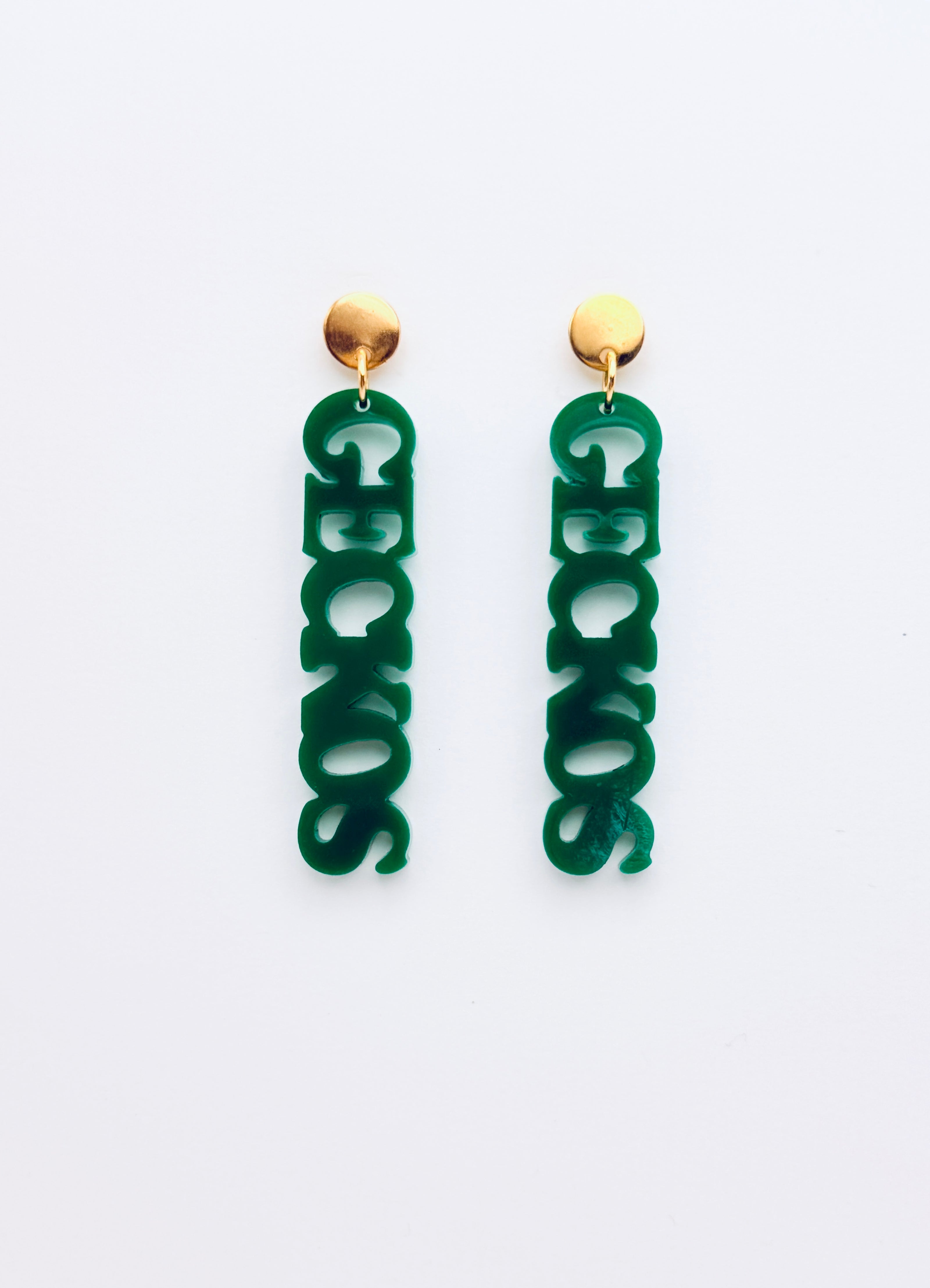 Green earrings with gold tops on a white background