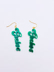Green script earrings on a light blue background