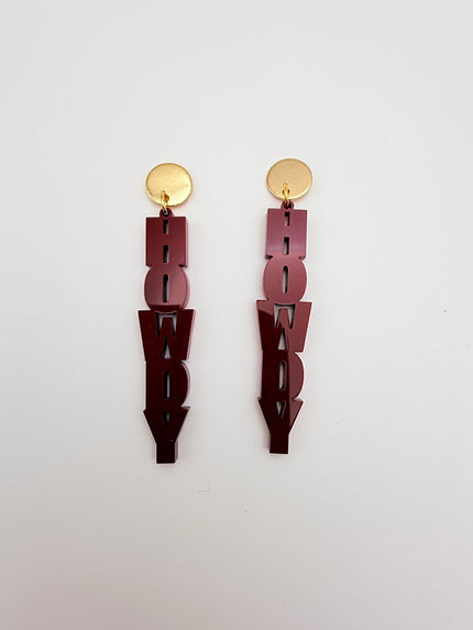 Pair of maroon earrings with gold studs on a light gray background