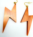 A pair of lightning bolt-shaped drop earrings made of copper-colored acrylic with gold-tone fishhook wires, displayed on a clean white background.