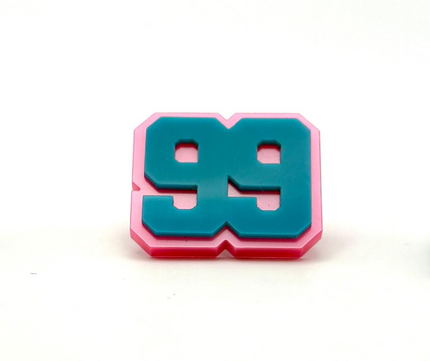 A custom acrylic pin with the number 99, predominantly blue with a pink border, with a stainless steel pin back closure.