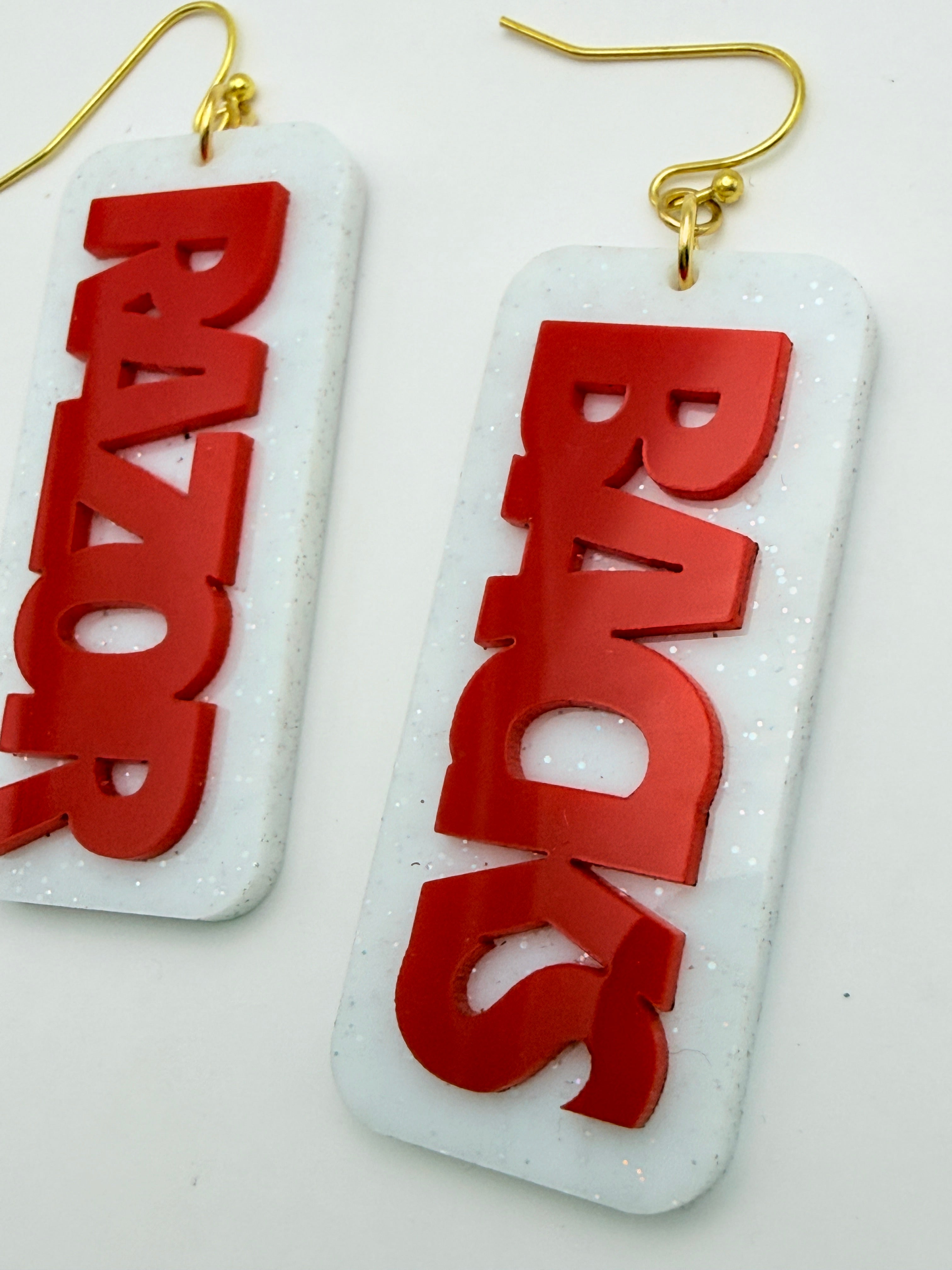 Earrings with 'BACKS RAZOR' text on a white background