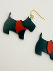 Black and red dog-shaped earrings on a light gray background