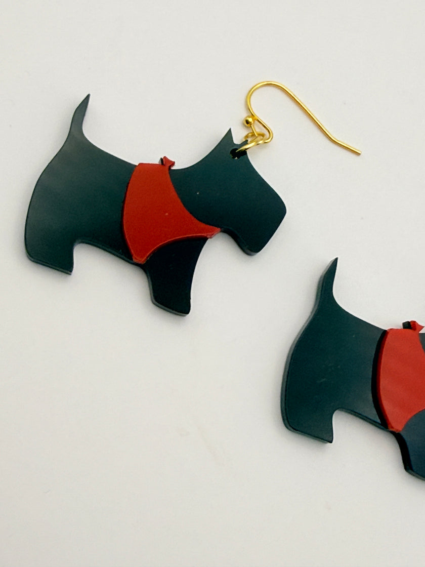 Black and red dog-shaped earrings on a light gray background