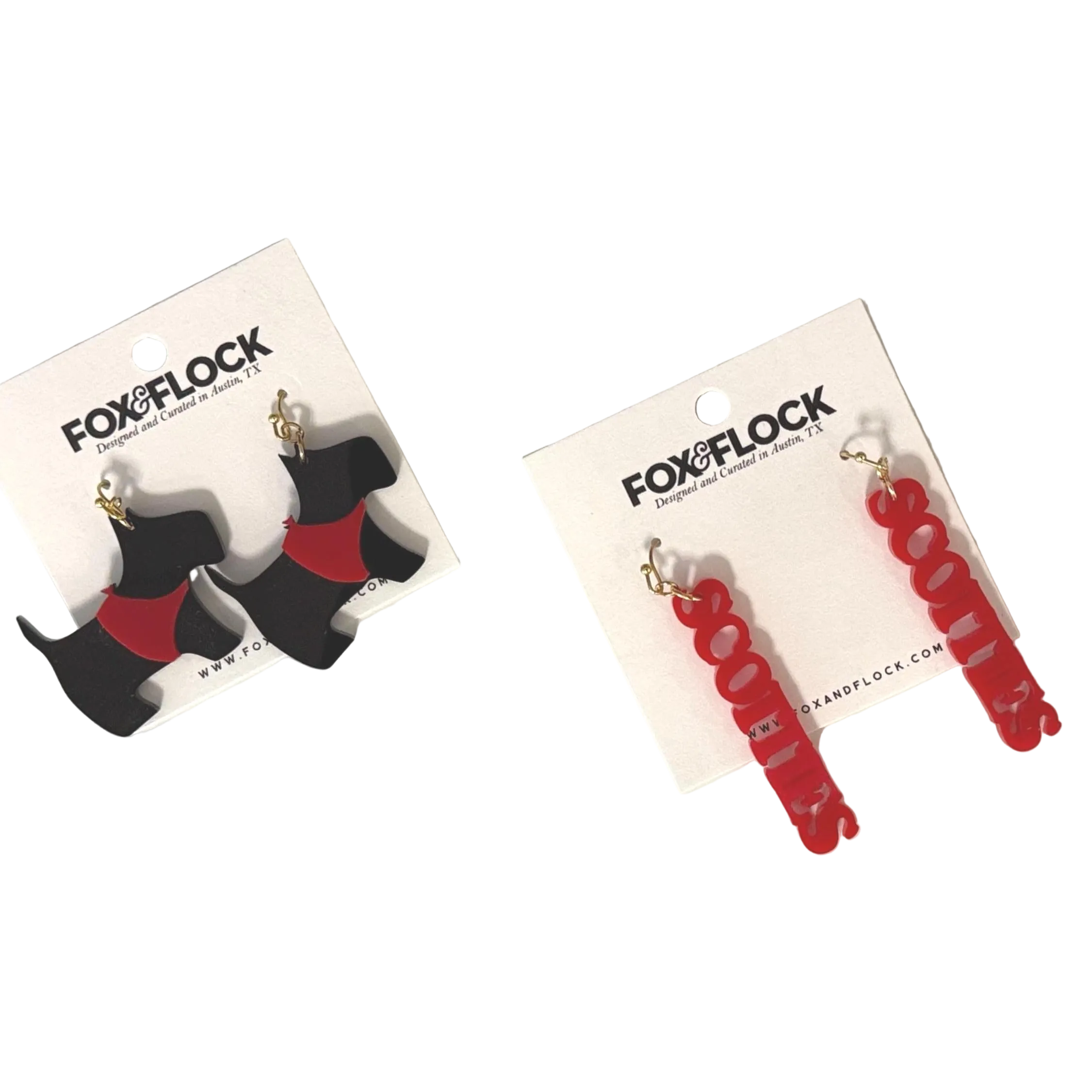 A pair of acrylic earrings in the shape of Scottie dogs, predominantly black with red accents, displayed on white cards with the Fox&Flock branding.