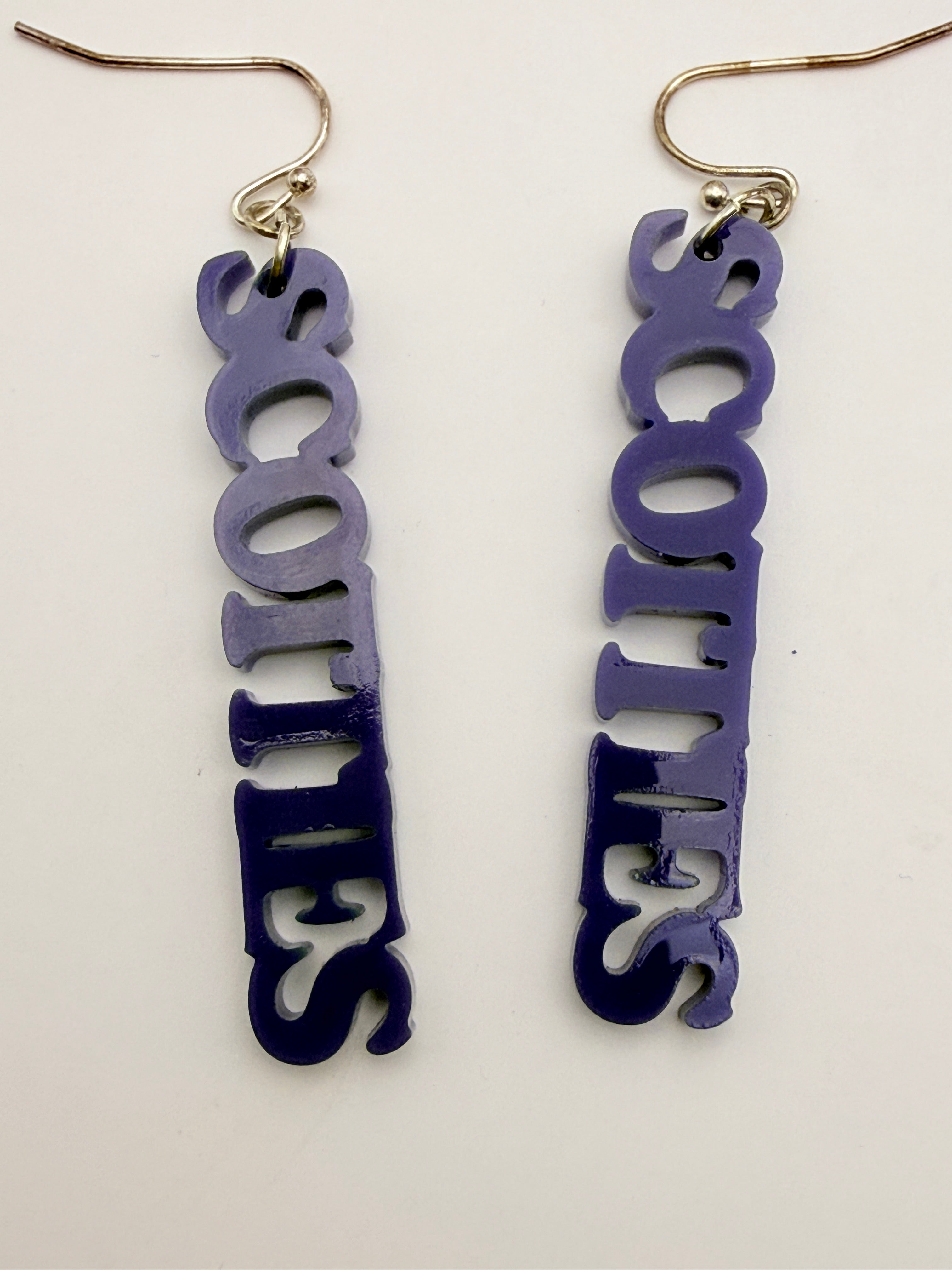 Pair of earrings with 'SCOTTIES' text on a white background