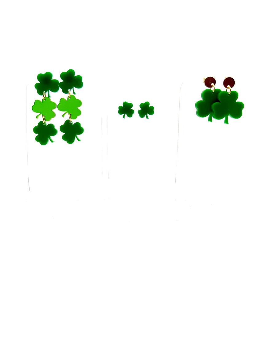 A collection of green shamrock-shaped earrings with gold plating on studs and hardware, displayed on a white background.