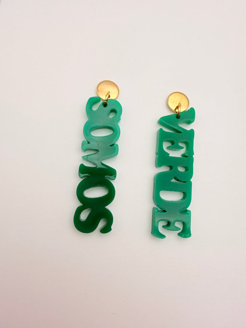 Green earrings with 'VERDE SOMOS' text on a light gray background