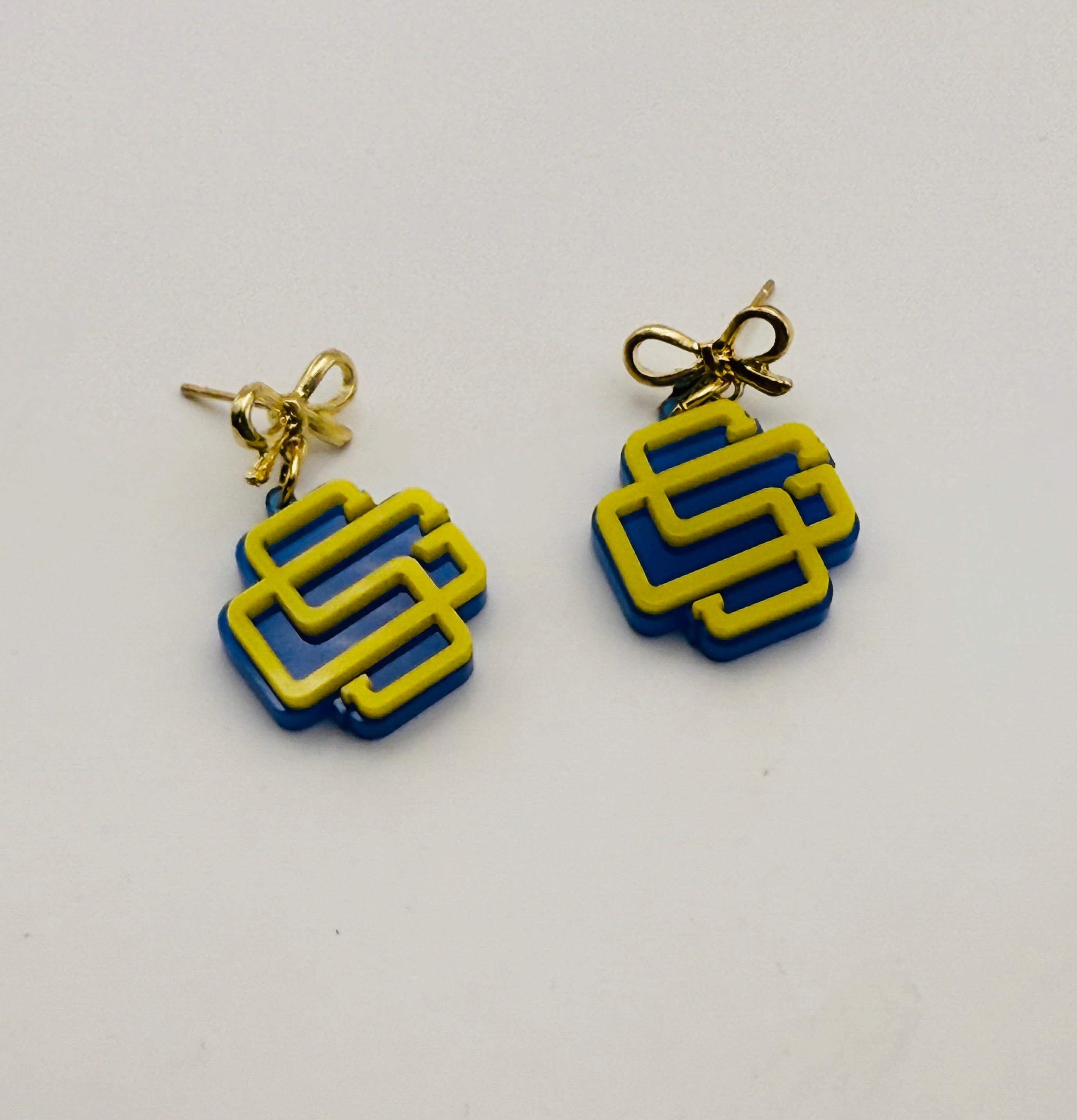 Pair of earrings with blue and yellow geometric design on a white background