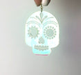 Glowing skull-shaped pendant on a gray background
