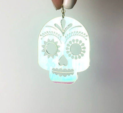 Glowing skull-shaped pendant on a gray background