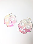 Pair of skull-shaped earrings with pink and white gradient on a white background