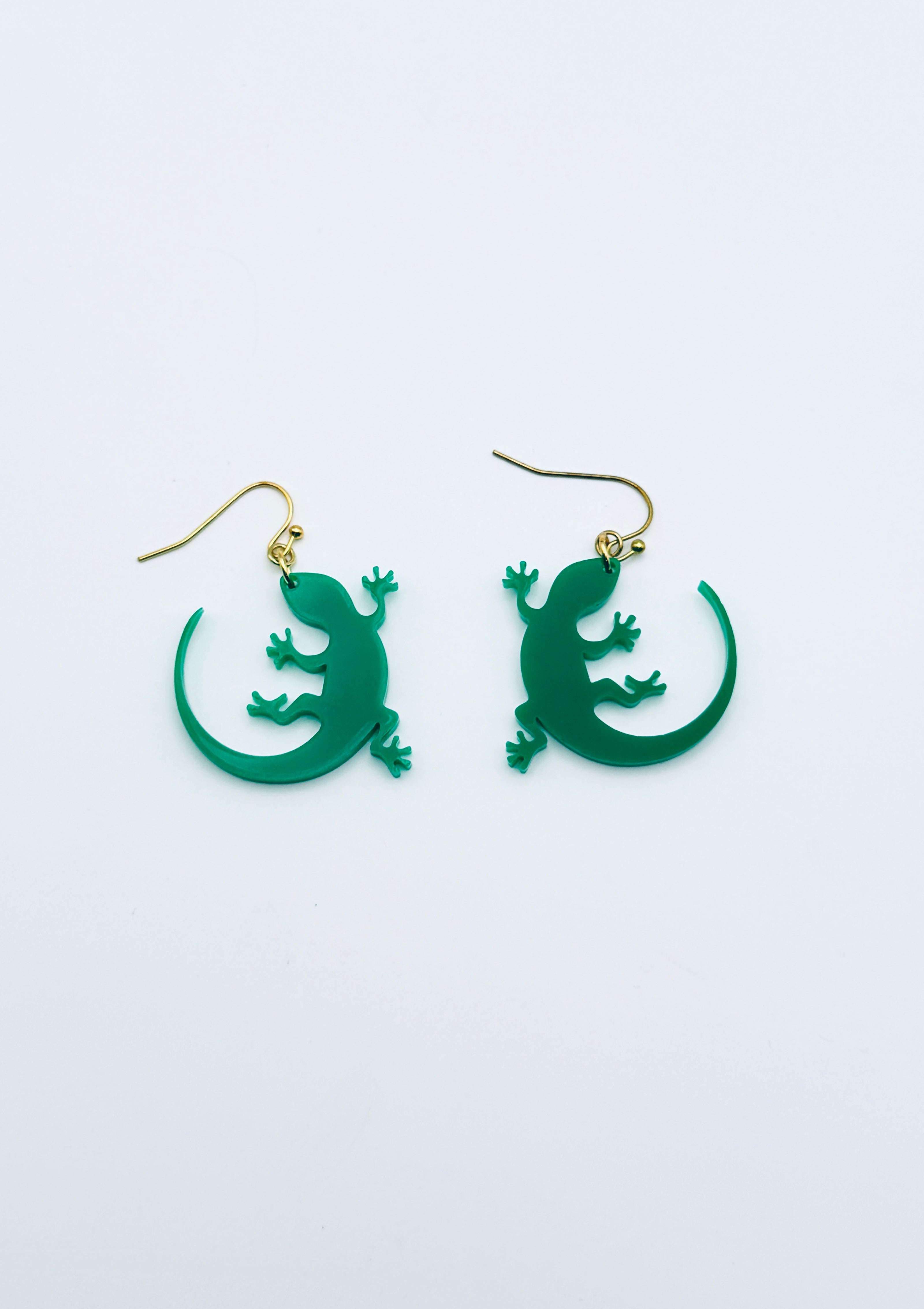 Green lizard-shaped earrings on a white background