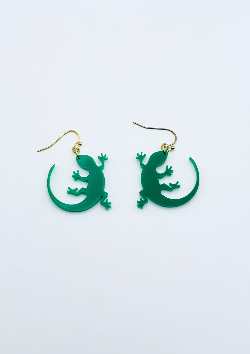 Green lizard-shaped earrings on a white background