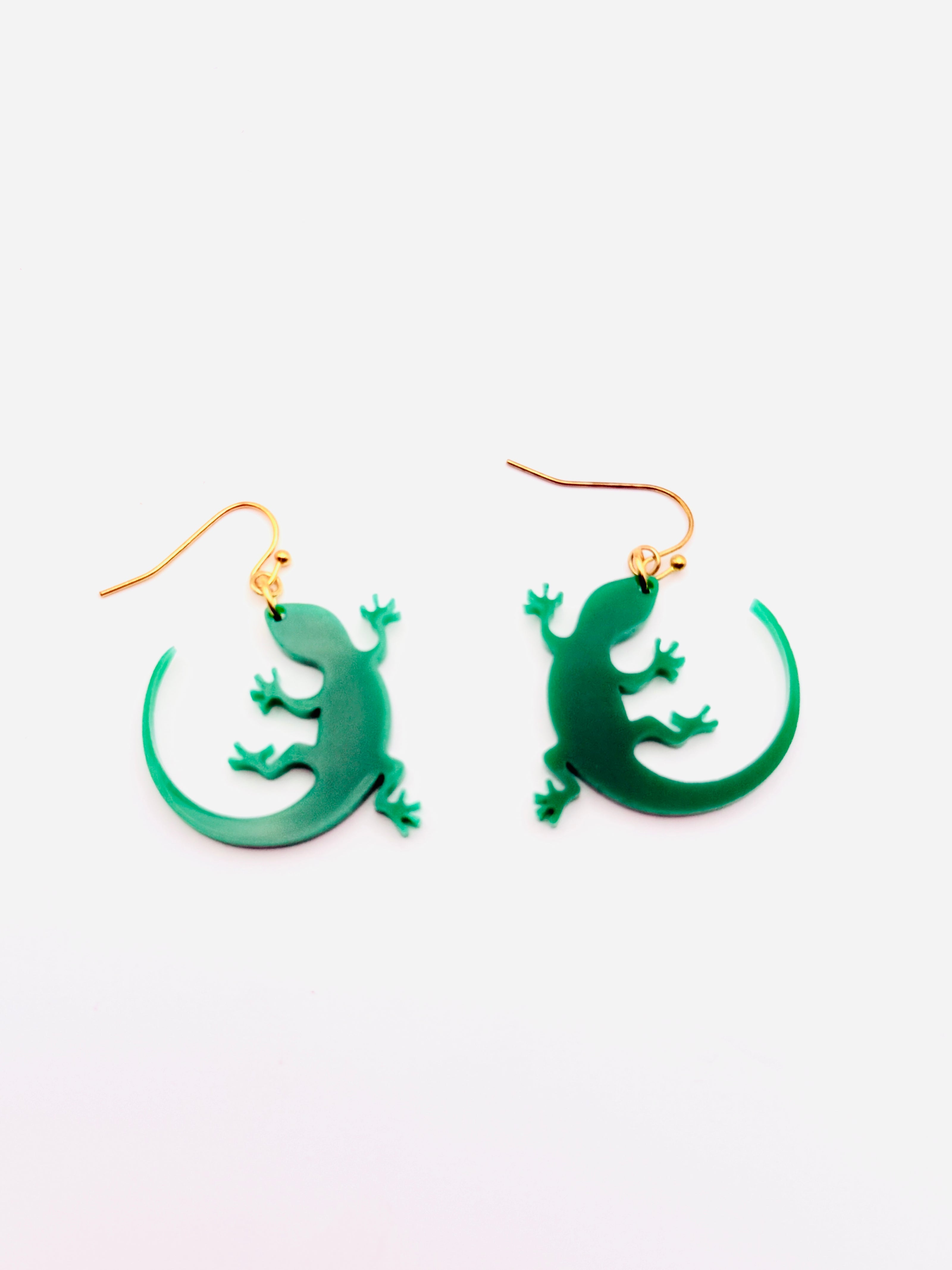 Green lizard-shaped earrings on a white background