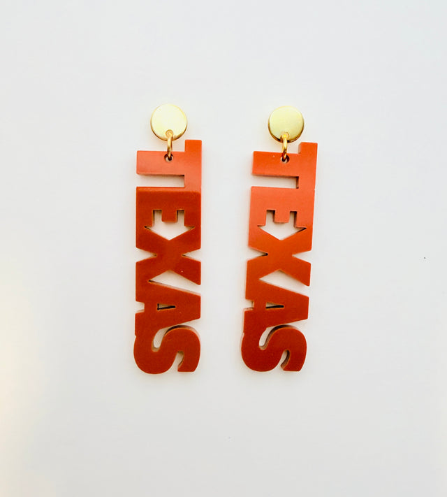 Orange 'TEXAS' earrings on a white background