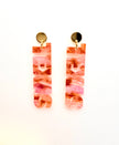 Pair of pink marbled earrings on a white background