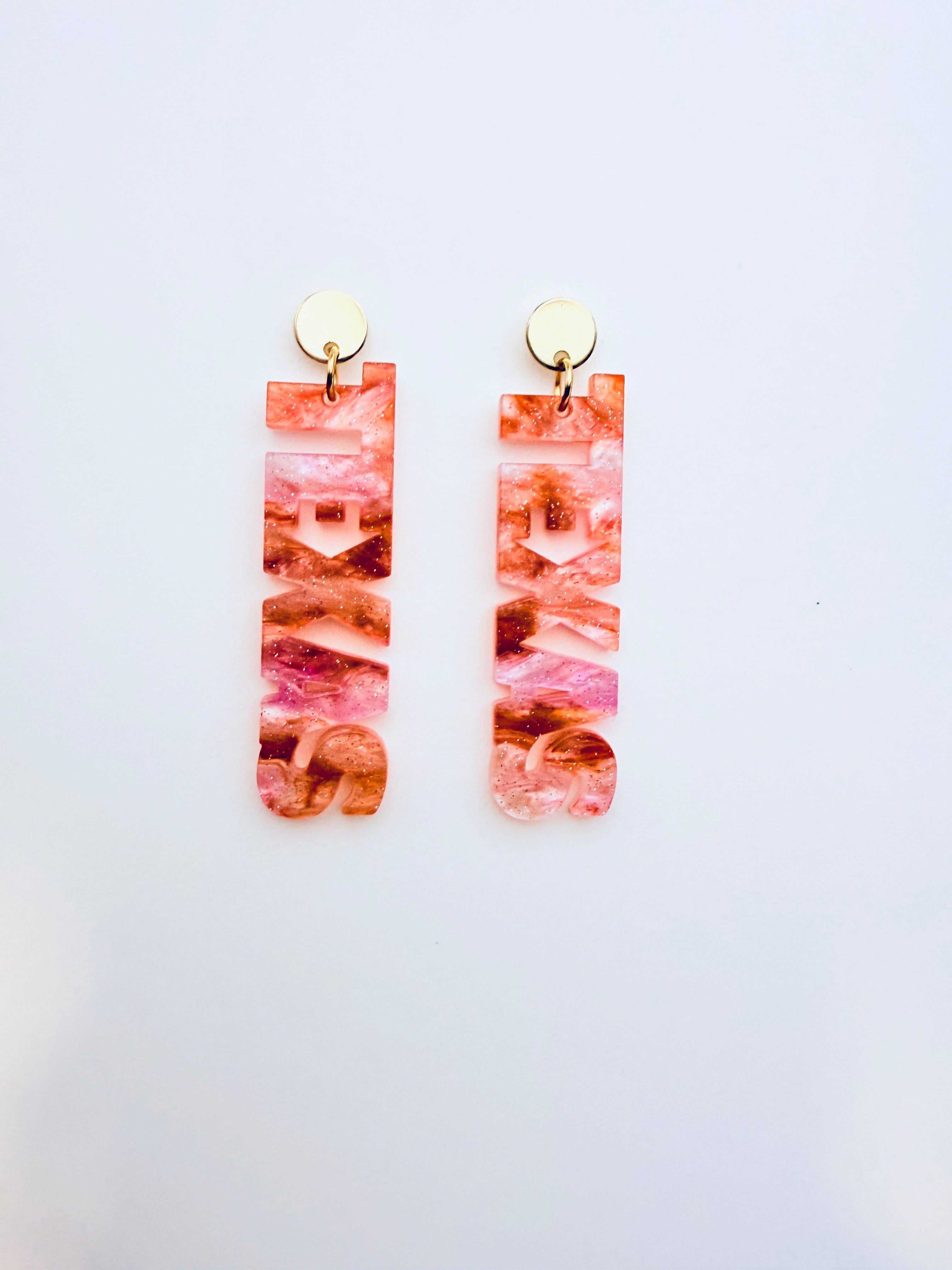 Pair of burnt orange marbled earrings on a white background