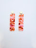 Pair of burnt orange marbled earrings on a white background