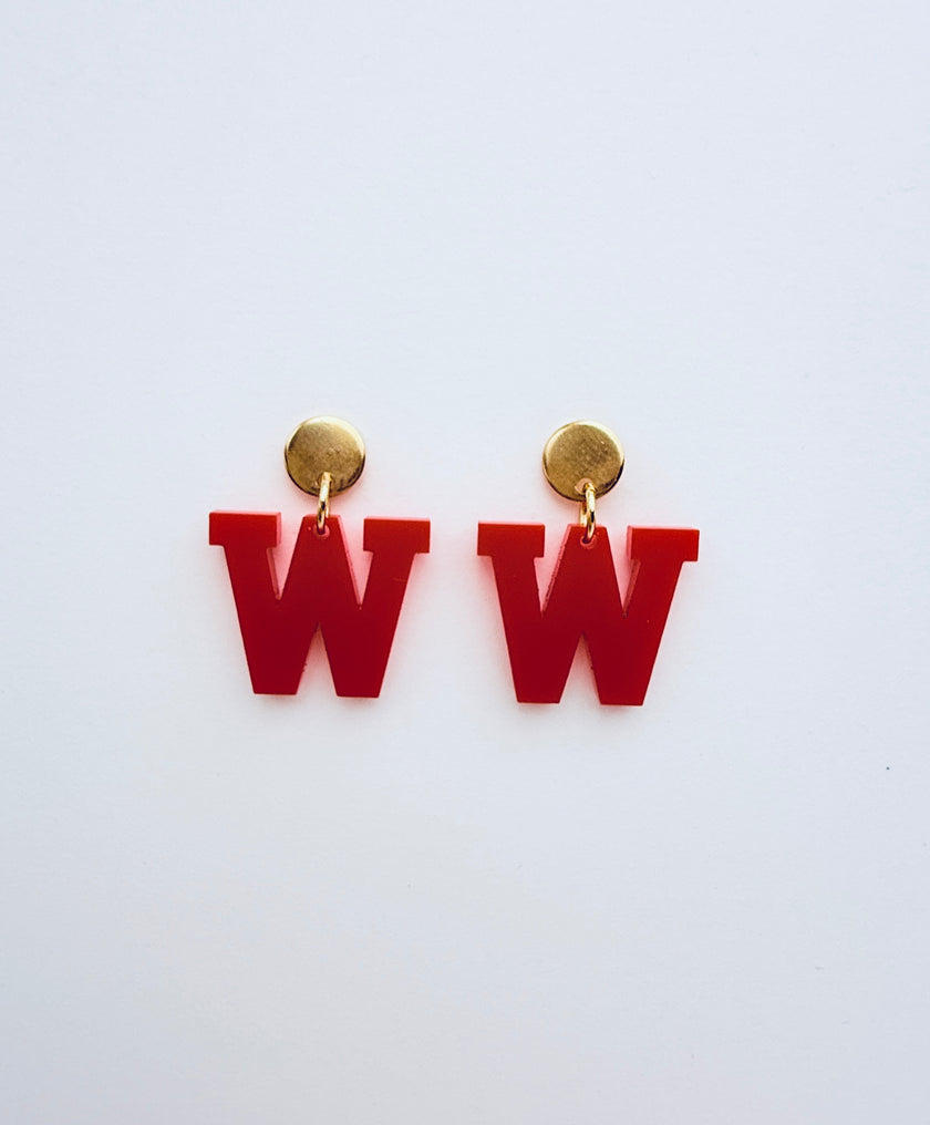 Red letter 'W' earrings with gold studs on a white background