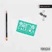 A personalized green notecard with a hand-drawn Starla name, placed on a white background alongside a pencil and an envelope.
